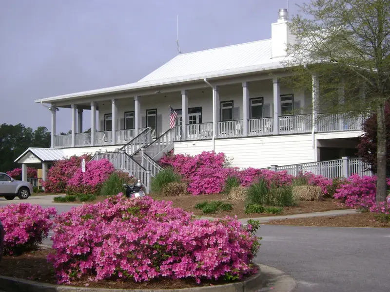 Azaleas in full bloom below the clubhouse porch and its American flag