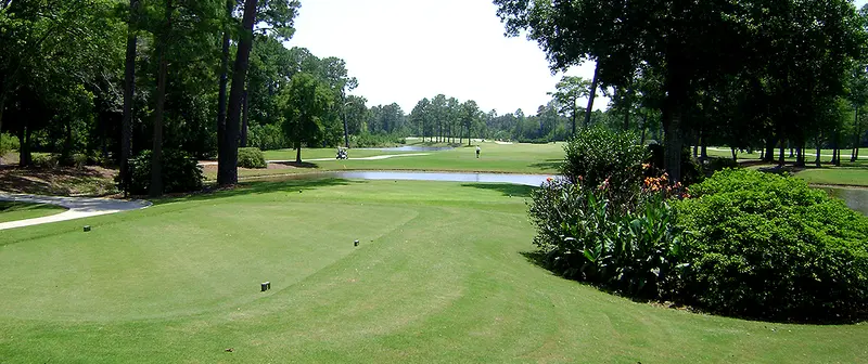 View from a tee box across a water crossing to the fairway beyond