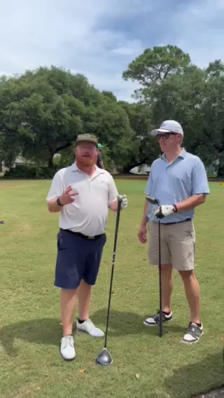 Two golfers leaning on their drivers on a tee box at Gulf Shores Golf Club